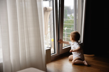 Young blonde mother having quality time with her baby boy son at family home flat - Wearing black budoir dress costume sleeping gown