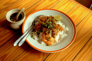 Stir fried prawns with garlic and Thai chili topped with rice, eaten with fish sauce chili, very tasty