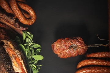 Composition of cold cuts on a dark background. Top view, room for text