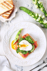 Sliced poached egg with fish sandwich on a gray background. View from above. The concept of delicious and healthy breakfasts.