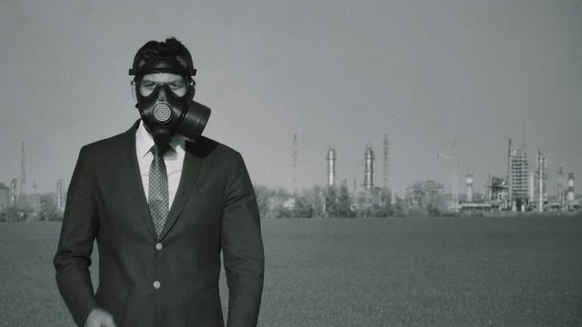 Environmental pollution. Male in Protective Mask Near Nuclear Power Station