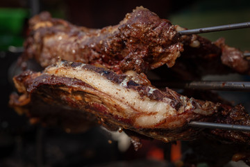 Marinated fried pork ribs cooked on a skewer over charcoal