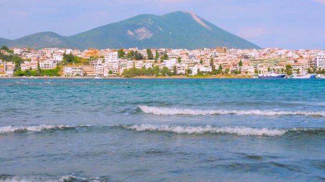Seascape with small waves and buildings on background Touristic city, island. Euboea, Greece. City of Chalkida. Traveling concept. City and seascape with beautiful color of water Global refugee crisis