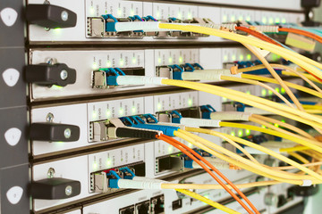 Front panel of the central router. Fiber optic communication lines of the main Internet channel. Computer equipment is in the server room of the datacenter. Information technology concept.