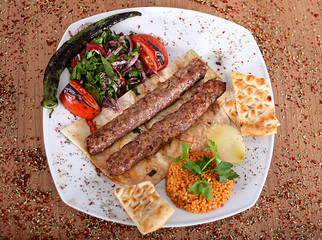 Roasted turkey kebabs  on a wooden table filled with Turkish spices