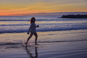 funny girl at sunset on the beach
