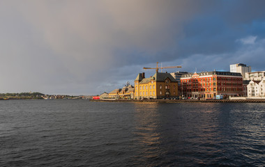 Stavanger, Norway - July 2019: The harbour in Stavanger city. This area is called Vågen. Evening with the rainbow
