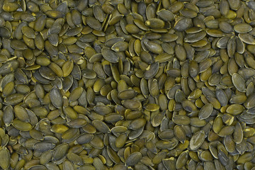 Top view of green dried shell free pumpkin seeds food background