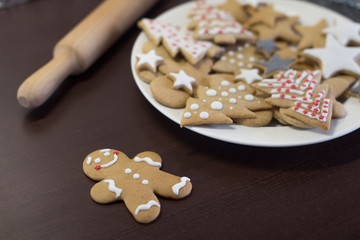 gingerbread cookies on a white plate on a dark brown wooden table