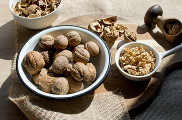 Full bowl of walnuts on the wooden table in the kitchen. Healthy snack for christmas time. Close up and top view.