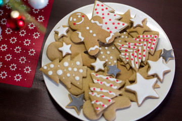 gingerbread cookies on a white plate on a dark brown wooden table