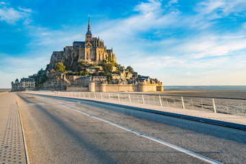 Obraz premium Access road to Mont Saint Michel and its Abbey with the sea at low tide.