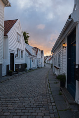 Fototapeta na wymiar Traditional wooden houses in Gamle Stavanger. Gamle Stavanger is a historic area of the city of Stavanger in Rogaland, Norway. Beautiful summer sunset with coloured sky. July 2019