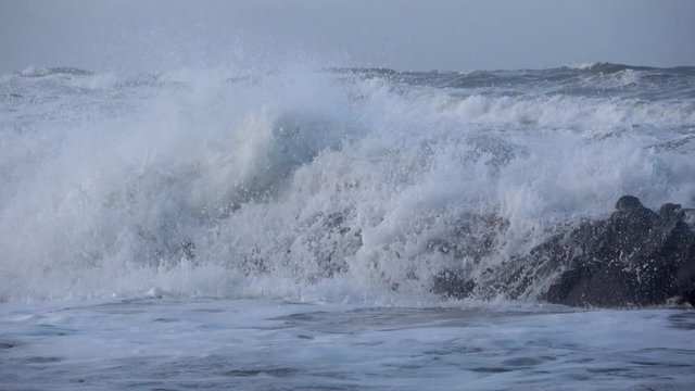 Waves rolling on the beach is a stormy day, winter mediterranean sea. Focene, Lazio, Italy. Slow motion