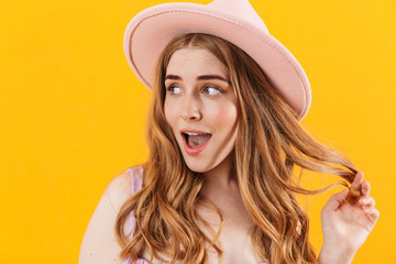 Cheerful happy girl isolated over yellow wall background wearing hat.