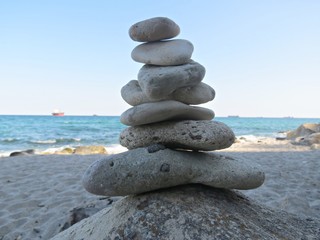 Fototapeta na wymiar Zen stone stack near the sea. Harmony, balance and simplicity concept. Poise pebbles, zen sculpture, beach stone cairn.