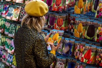 AMSTERDAM, NETHERLANDS- September 18, 2019: Young woman shopping for flower seeds in famous flower...