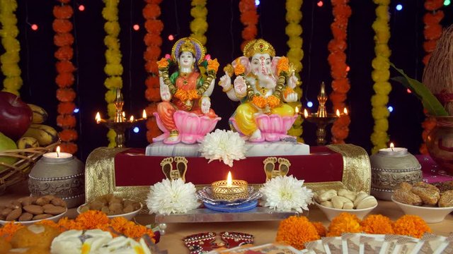Beautiful temple/Puja Ghar of Hindu gods Ganesh Ji and Laxmi Ji on Diwali - the festival of lights. Lord Ganesha and Goddess Lakshmi idols surrounded by Diyas  Kalash  coconut  fruits  Indian rupee...
