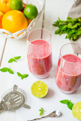 Two Glasses of Smoothie with Berries, Grapefruit, Lemon, Lime and Mint on White Wooden Background, Detox Time