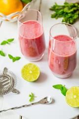 Two Glasses of Smoothie with Berries, Grapefruit, Lemon, Lime and Mint on White Wooden Background, Detox Time