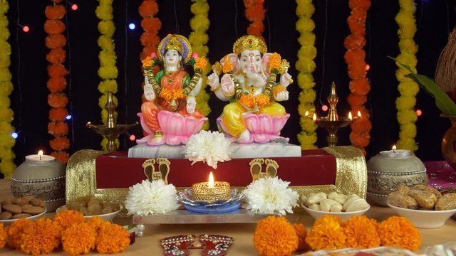 Moving shot of Lord Ganesha and Goddess Lakshmi on the festival of Diwali/Dipavali. Decorated Indian temple/mandir/puja Ghar with Hindu gods Laxmi and Ganesh with floral lights in the background