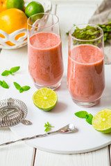 Two Glasses of Smoothie with Berries, Grapefruit, Lemon, Lime and Mint on White Wooden Background, Detox Time