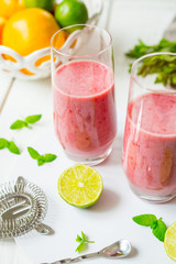Two Glasses of Smoothie with Berries, Grapefruit, Lemon, Lime and Mint on White Wooden Background, Detox Time