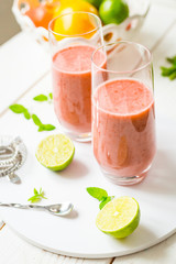 Two Glasses of Smoothie with Berries, Grapefruit, Lemon, Lime and Mint on White Wooden Background, Detox Time