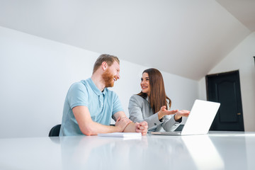 Low angle image of smiling businesswoman talking to a male client in bright office, copy space.