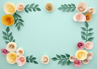 Paper flowers and leaves on blue background