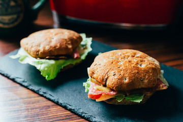 Toasts with Salami or Ham, Cheese, Pickles, Lettuce and Mustard on the Black Stone Board