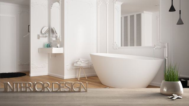 Wooden table, desk or shelf with potted grass plant, house keys and 3D letters making the words interior design, over blurred modern bathroom, project concept copy space background