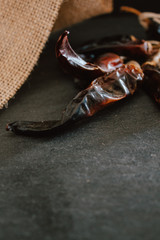 zenith Hot chilli pepper on black background with rustic cloth, vintage tablecloth. Spicy traditional with copyspace.