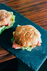 Toasts with Salami or Ham, Cheese, Pickles, Lettuce and Mustard on the Black Stone Board