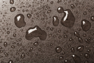 Rain droplets on brown glass background, Water drops on blue glass.