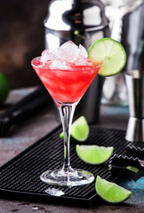Watermelon cobbler, alcoholic cocktail with vodka, lemon juice, mint, lime and crushed ice, metal bar tools, dark background