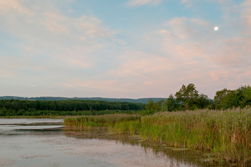 colorful moon on autumn lake at dawn with forest