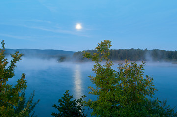 Fototapeta na wymiar colorful moon on autumn lake at dawn with forest