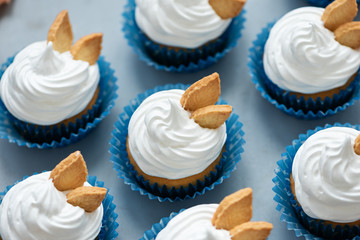 Autumn cupcakes decorated with cream and cookies leaves on gray wooden background. Soft focus. Thanksgiving day or Halloween celebration concept