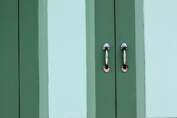 metal handle of a green classic wooden window.