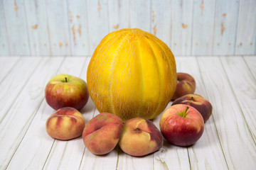 Melon Ethiopian peaches apples on a wooden table. Raw organic fruit. Useful product.