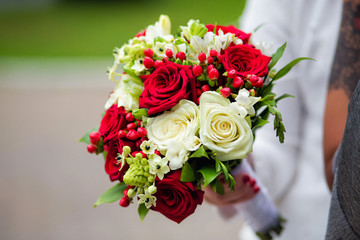 bouquet of white and red roses in the hands of the bride