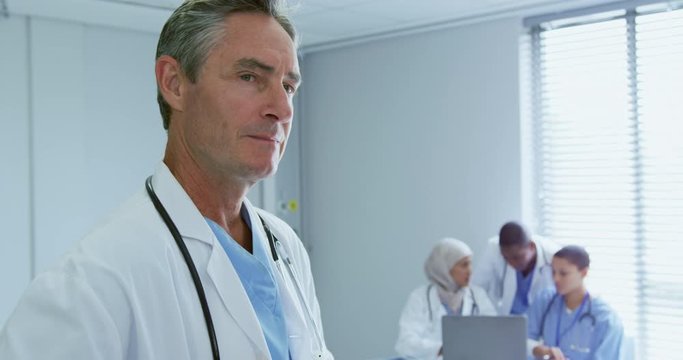 Close-up of Caucasian male doctor looking at his colleagues in hospital