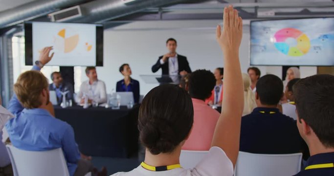 Businessman inviting questions from the audience at a business conference