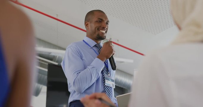 Male speaker addressing applauding audience at a business seminar
