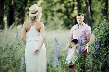 a father with a son look at a mother among greenery lawn