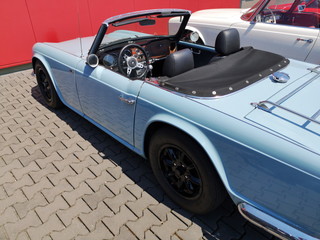 Offener englischer Roadster und Sportwagen der Sechzigerjahre in Hellblau mit Gepäckbrücke im...