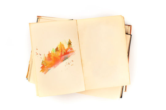 Autumn design template. An open botanical journal with a watercolour sketch of fall trees. An artist's sketchbook mock-up, shot from the top on a white background with a place for text