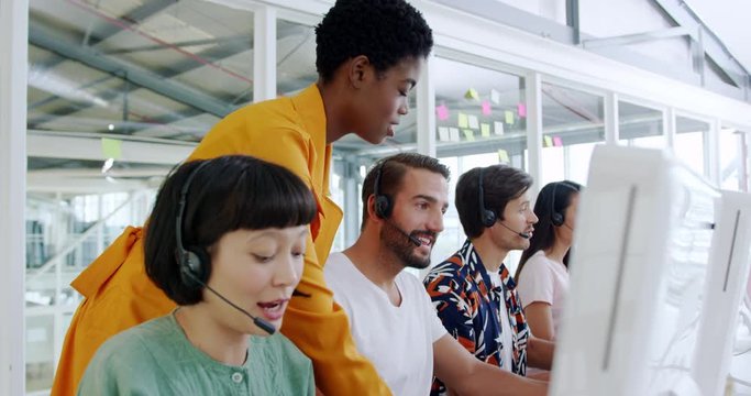 Mixed race call centre staff working in a modern office