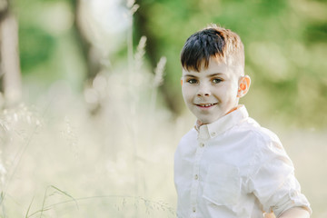 a little boy portrait among greenery lawn
